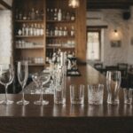 Σειρά επαγγελματικών ποτηριών σε ξύλινο πάγκο μπαρ: κρασιού, σαμπάνιας, coupe, σωλήνας, χαμηλό, ουίσκι, μπύρας και σφηνάκι