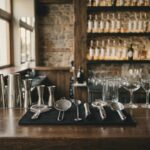 Εργαλεία bartender στη σειρά πάνω σε πάγκο μπαρ: σέικερ, μεζούρες, σουρωτήρια, κουτάλι μπαρ και σέσουλα πάγου