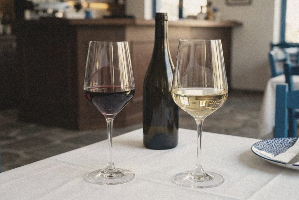 Ποτήρια κρασιού Vicrila Mencia και Crystal Bohemia Strix με κόκκινο και λευκό κρασί σε τραπέζι εστιατορίου